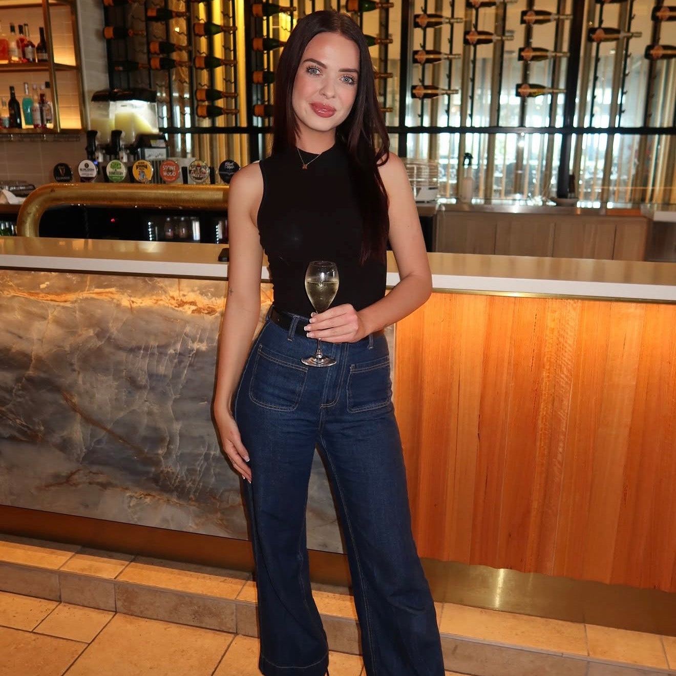 Woman holding a glass in a bar setting